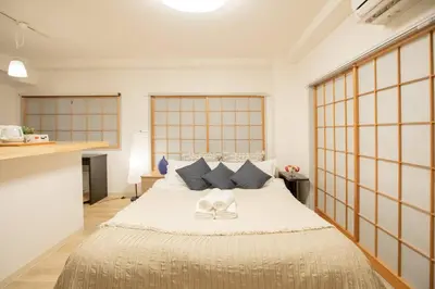 a bedroom with a large bed with two white shoes on it at KEYHOTEL-5minutes for walk to Akihabara Electric Town in Tokyo