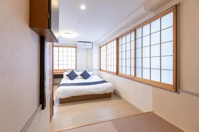 a bedroom with a bed and two windows at KEYHOTEL-5minutes for walk to Akihabara Electric Town in Tokyo