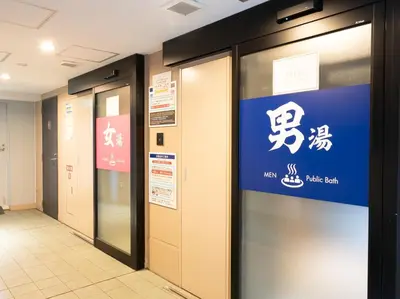 a row of elevators in a building with a sign at Tabist TOKYO CITY VIEW HOTEL in Tokyo