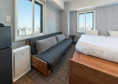 a hotel room with a bed and a couch at Tabist TOKYO CITY VIEW HOTEL in Tokyo