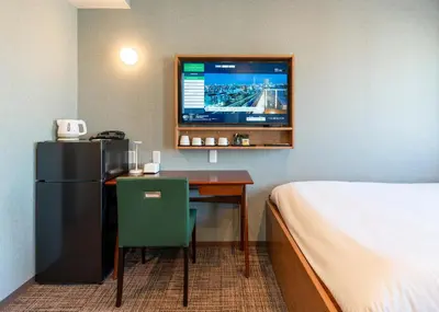 a hotel room with a desk with a bed and a tv at Tabist TOKYO CITY VIEW HOTEL in Tokyo