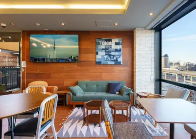 a restaurant with a couch and tables and a view at Tabist TOKYO CITY VIEW HOTEL in Tokyo