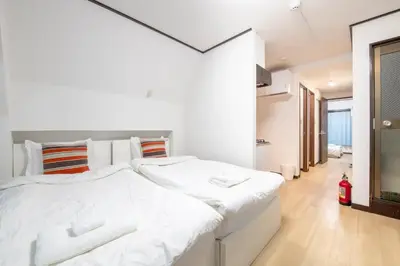 a white bedroom with a large white bed in it at Uhome Tabata Apartment in Tokyo