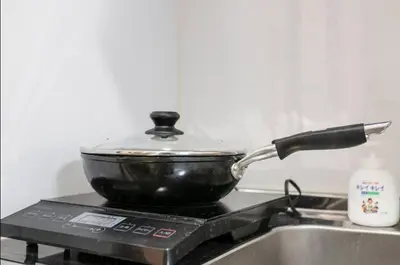 a pan on top of a stove with a pot on it at Uhome Tabata Apartment in Tokyo