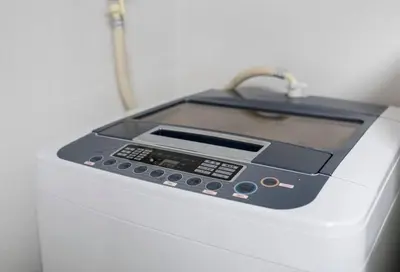 a electronic device sitting on top of a washing machine at Uhome Tabata Apartment in Tokyo
