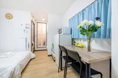 a room with a table with a vase of flowers at Uhome Tabata Apartment in Tokyo