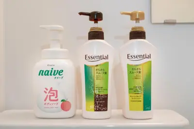 three bottles of cleaning products sitting on a sink at Uhome Tabata Apartment in Tokyo