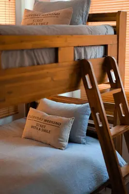 a wooden bunk bed with a chair and a pillow at ZAITO Tokyo Kinshicho Economy Inn \u5b85\u4e1c\u4e1c\u4eac\u6a2a\u5ddd1\u6c11\u5bbf in Tokyo
