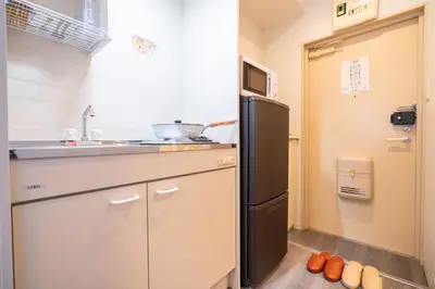 a kitchen with a black refrigerator and a sink at ZAITO Tokyo Kinshicho Economy Inn \u5b85\u4e1c\u4e1c\u4eac\u6a2a\u5ddd1\u6c11\u5bbf in Tokyo