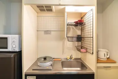 a small kitchen with a sink and a microwave at ZAITO Tokyo Kinshicho Economy Inn \u5b85\u4e1c\u4e1c\u4eac\u6a2a\u5ddd1\u6c11\u5bbf in Tokyo