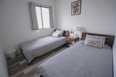 a bedroom with two beds and a window at ZAITO Tokyo Kinshicho Economy Inn \u5b85\u4e1c\u4e1c\u4eac\u6a2a\u5ddd1\u6c11\u5bbf in Tokyo