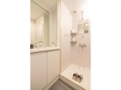 a white bathroom with a sink and a shower at ZAITO Tokyo Kinshicho Economy Inn \u5b85\u4e1c\u4e1c\u4eac\u6a2a\u5ddd1\u6c11\u5bbf in Tokyo
