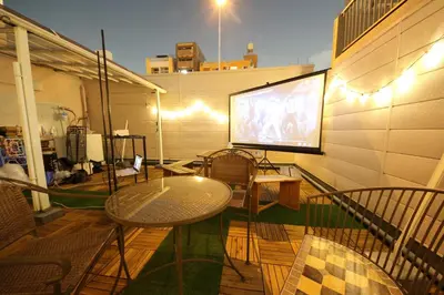 a balcony with a table and chairs and a projection screen at Casa HANA in Tokyo