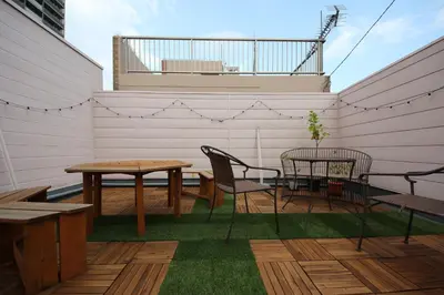 a patio with a table and chairs on a deck at Casa HANA in Tokyo