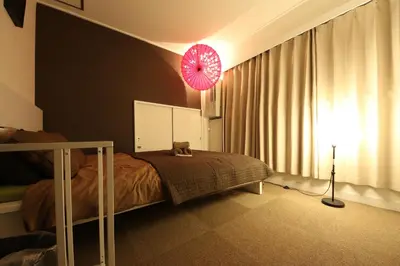 a bedroom with a bed and a pink umbrella at Casa HANA in Tokyo