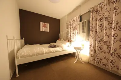 a bedroom with a white bed and a window at Casa HANA in Tokyo