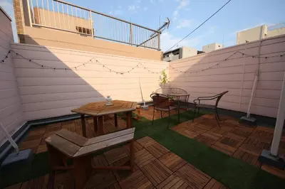 a patio with two tables and chairs on a balcony at Casa HANA in Tokyo