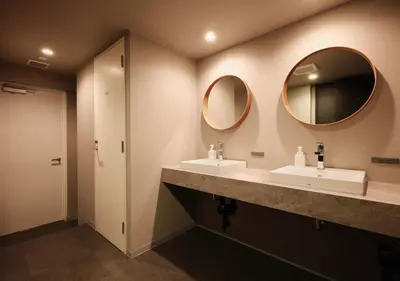 a bathroom with two sinks and two mirrors at Hotel Graphy Nezu in Tokyo