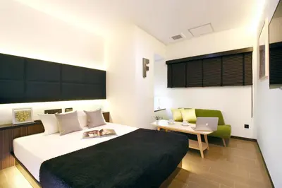 a bedroom with a bed with a cat laying on it at Hotel DUO kinsicho in Tokyo