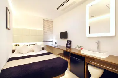 a bathroom with a bed and a sink at Hotel DUO kinsicho in Tokyo