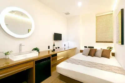 a bedroom with a bed and a sink and a mirror at Hotel DUO kinsicho in Tokyo
