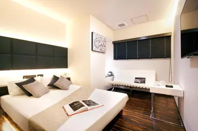 a hotel room with two beds and a desk at Hotel DUO kinsicho in Tokyo