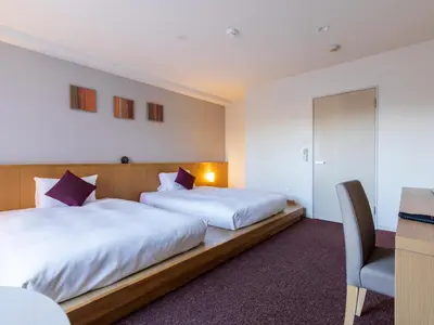 a hotel room with two beds and a chair at Tokyu Stay Monzen-Nakacho Tokyo in Tokyo