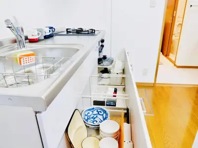a kitchen counter with an open drawer with dishes at Triphome Ikebukuro Tokyo Max 7ppls FREE WIFI in Tokyo