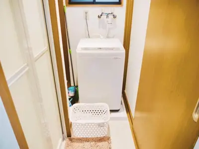 a small bathroom with a sink and a washing machine at Triphome Ikebukuro Tokyo Max 7ppls FREE WIFI in Tokyo