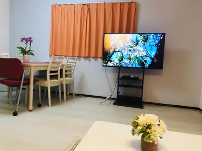 a living room with a tv and a table with chairs at K House in Tokyo