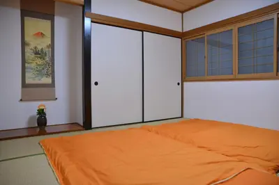 a bedroom with an orange bed and a window at K House in Tokyo