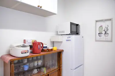 a kitchen with a white refrigerator and a microwave at K House in Tokyo