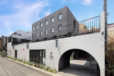 a white brick building with an archway at HOTEL CEN in Tokyo