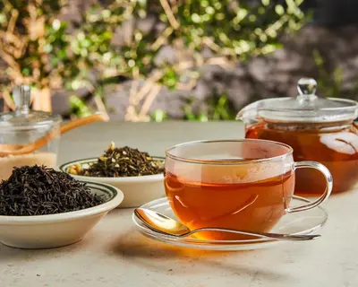 a cup of tea on a table with bowls of black tea at HOTEL CEN in Tokyo