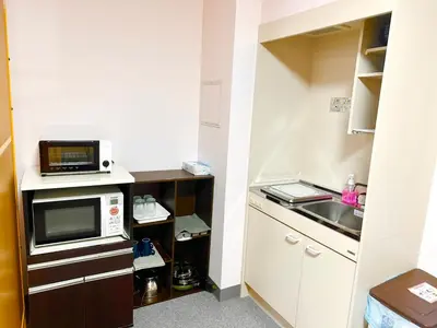 a small kitchen with a microwave and a sink at Sakura Hotel Jimbocho in Tokyo