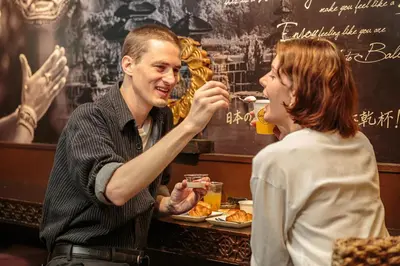 a man feeding a woman a plate of food at Hotel Balian Resort Higashi Shinjuku in Tokyo