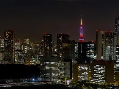 a city skyline at night with a lit up tower at Ginza Creston in Tokyo