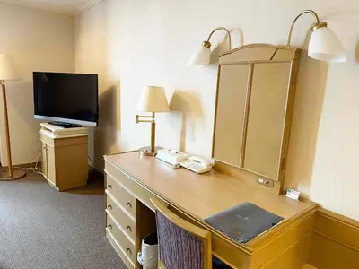 a hotel room with a desk with a mirror and a tv at Ginza Creston in Tokyo