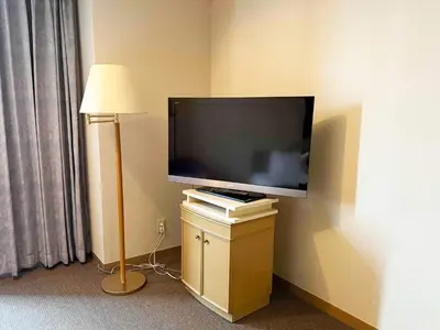 a flat screen tv on a wall next to a lamp at Ginza Creston in Tokyo