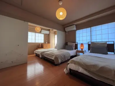 a bedroom with two beds and two windows at Spacious Tokyo Apartment for 6-8 Guests!! 1 min to Morisita Station , Direct to Shinjuku in Tokyo