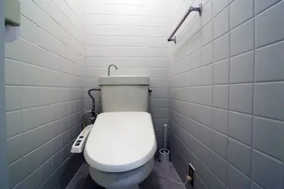 a white toilet in a bathroom with white tiles at Spacious Tokyo Apartment for 6-8 Guests!! 1 min to Morisita Station , Direct to Shinjuku in Tokyo