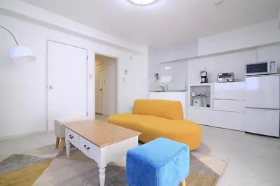 a living room with a yellow couch and a table at Spacious Tokyo Apartment for 6-8 Guests!! 1 min to Morisita Station , Direct to Shinjuku in Tokyo