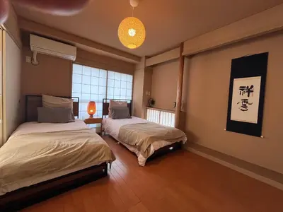a room with two beds and a chinese sign on the wall at Spacious Tokyo Apartment for 6-8 Guests!! 1 min to Morisita Station , Direct to Shinjuku in Tokyo