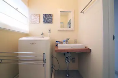 a small bathroom with a sink and a refrigerator at Spacious Tokyo Apartment for 6-8 Guests!! 1 min to Morisita Station , Direct to Shinjuku in Tokyo