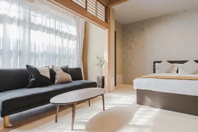 a bedroom with a bed and a couch and a table at Playsis Asakusa in Tokyo