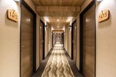 a hallway with wooden walls and a long hallway with wooden doors at HOTEL AMANEK Kamata-Eki Mae in Tokyo