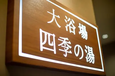 a sign with chinese writing on a wooden wall at HOTEL AMANEK Kamata-Eki Mae in Tokyo