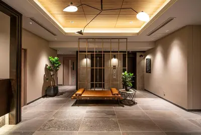 a lobby with a bench in the middle of a building at HOTEL AMANEK Kamata-Eki Mae in Tokyo