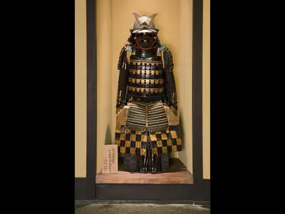 a statue of a samurai in a display case at The Edo Sakura in Tokyo