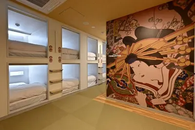 a room with bunk beds with a painting on the wall at Hotel Tomariya Ueno in Tokyo